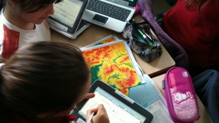 children working on a project using ipad