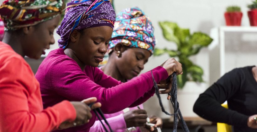 Photo of women working to produce woven carpets