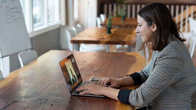 A women watches a presentation on her laptop