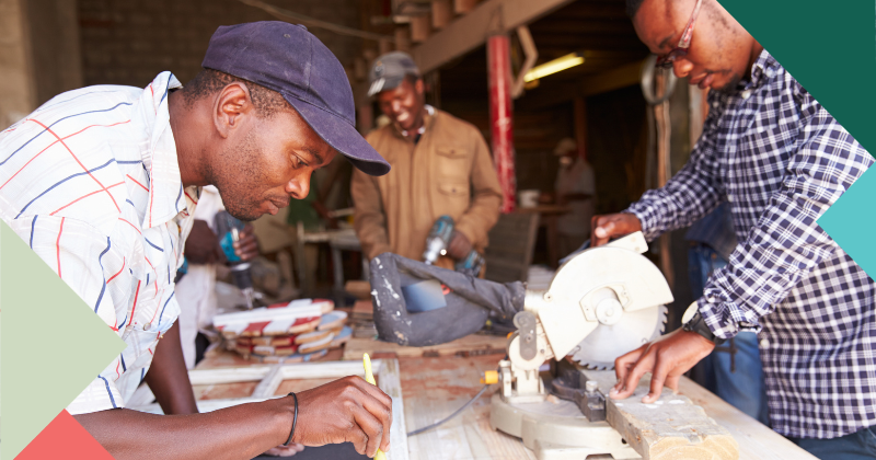 Three African men employed in a carpentry workshop