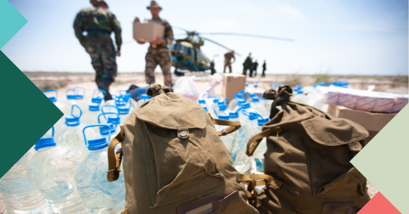 Humanitarian aid in the form of water bottle supplies are delivered by militarty helicopter. 